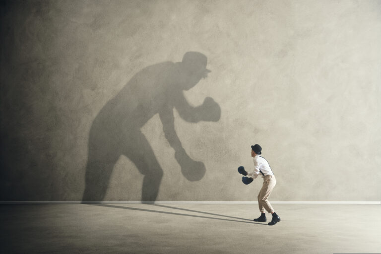 man fighting with his shadow, facing imposter syndrome
